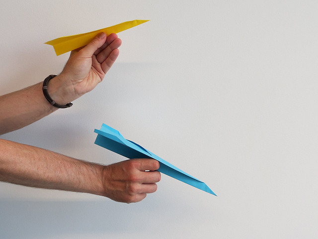 Zwei unterschiedliche Papierflieger bereit zum Fliegen.